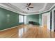 A bedroom featuring hardwood floors, tray ceiling, fan and ensuite bathroom at 100 Burlingame Way, Cary, NC 27513