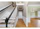 Elegant staircase with hardwood steps and black railing leads to the upper level at 100 Burlingame Way, Cary, NC 27513