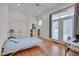 Bright bedroom featuring hardwood floors, a cozy bed, and double doors to a front porch at 101 Overlake Dr, Chapel Hill, NC 27516