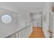 Second floor hallway with a round window, white trim, and hardwood floors at 101 Overlake Dr, Chapel Hill, NC 27516