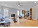 Bright living room featuring hardwood floors, fireplace, and built-in shelving with a ceiling fan at 101 Overlake Dr, Chapel Hill, NC 27516