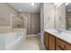 Bright bathroom with a soaking tub, glass shower, and double vanity with wood cabinets at 1012 Palace Garden Way, Raleigh, NC 27603