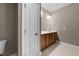 Neutral toned bathroom with a wood vanity, large mirror and tile flooring at 1012 Palace Garden Way, Raleigh, NC 27603