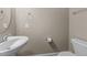 A half bath with a pedestal sink, toilet, and beige walls at 1012 Palace Garden Way, Raleigh, NC 27603