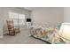 Bright bedroom with a floral bedspread, rocking chair, window, and dresser; carpeted flooring adds warmth at 1012 Palace Garden Way, Raleigh, NC 27603