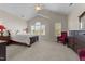 Main bedroom featuring a vaulted ceiling, cozy red chairs, and ample natural light from large windows at 1012 Palace Garden Way, Raleigh, NC 27603