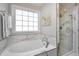 Luxurious bathroom with soaking tub, marble accents, and glass-enclosed shower at 104 Musgrove Cir, Cary, NC 27518