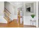 Hallway with hardwood floors, staircase, and view of kitchen at 104 Musgrove Cir, Cary, NC 27518