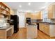 Kitchen featuring wood cabinets, black appliances, tile backsplash, and hardwood floors at 104 Musgrove Cir, Cary, NC 27518