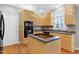 Bright kitchen featuring custom wood cabinets, island cooktop, and stainless appliances at 104 Musgrove Cir, Cary, NC 27518
