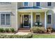 Front porch with columns, a wreath on the front door, and seating with decorative pillows at 104 Musgrove Cir, Cary, NC 27518