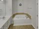 Bathroom with Jacuzzi tub with jets, single vanity, sink, and window view at 104 Walnut Creek Dr, Clayton, NC 27520