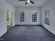 Spacious bedroom with plush gray carpeting, large windows, and a ceiling fan at 104 Walnut Creek Dr, Clayton, NC 27520