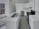 Bright kitchen with white cabinets, white counter tops, gray tile floor, and stainless appliances at 104 Walnut Creek Dr, Clayton, NC 27520