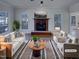 Staged living room featuring a fireplace, large windows, and elegant decor at 104 Walnut Creek Dr, Clayton, NC 27520