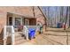 Back porch and exterior brick detail, as well as mature trees and a fence at 1253 Skyview Dr, Mebane, NC 27302