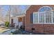 Close-up of a charming brick home featuring a covered porch and well-maintained landscaping at 1253 Skyview Dr, Mebane, NC 27302