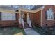 Inviting front entrance with white railings, brick accents, and a cozy covered porch at 1253 Skyview Dr, Mebane, NC 27302