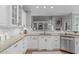 Well-lit kitchen with white cabinets and a granite countertop island with bar seating at 126 Maltland Dr, Cary, NC 27518