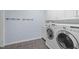 Laundry room featuring modern washer and dryer, white cabinets, and brick-style wall at 126 Maltland Dr, Cary, NC 27518