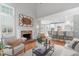 Open-concept living room with a brick fireplace and access to a white kitchen at 126 Maltland Dr, Cary, NC 27518