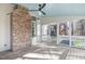 Relaxing screened porch featuring a cozy brick fireplace, ceiling fan, and natural light with wood flooring at 126 Maltland Dr, Cary, NC 27518
