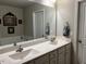 Bathroom vanity featuring a double sink, large mirror and cabinet storage at 133 Sandcastle Ln, Four Oaks, NC 27524