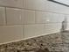 Close up of speckled granite countertop and white tiled backsplash at 133 Sandcastle Ln, Four Oaks, NC 27524