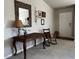 Inviting entryway with a dark wood table, rocking chair, and tasteful wall decor, leading to a white front door at 133 Sandcastle Ln, Four Oaks, NC 27524