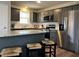 Stylish kitchen featuring granite countertops, gray cabinets, stainless steel appliances, and an island with seating at 133 Sandcastle Ln, Four Oaks, NC 27524