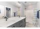 Bathroom featuring a double vanity, modern fixtures, gray cabinets and tiled floors at 183 Post Oak Rd, Chapel Hill, NC 27516
