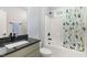 Bathroom featuring granite counters, gray vanity, and tub with colorful cactus themed shower curtain at 183 Post Oak Rd, Chapel Hill, NC 27516