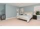 Light-filled bedroom features neutral carpet, ensuite access, large windows, ceiling fan, and dual night stands at 183 Post Oak Rd, Chapel Hill, NC 27516