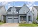 Beautiful, two-story home featuring gray siding, black trim, two-car garage, and charming front porch at 183 Post Oak Rd, Chapel Hill, NC 27516
