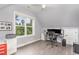Office featuring a sleek desk, plush carpeting, and a sunlit window with wooded view at 183 Post Oak Rd, Chapel Hill, NC 27516