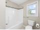 Bathroom features a shower-tub combo with decorative tiling and a window for natural light at 20 Jenmar Dr, Fuquay Varina, NC 27526