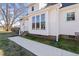 Exterior side view of white home showcasing large windows, brick foundation, and sidewalk at 20 Jenmar Dr, Fuquay Varina, NC 27526