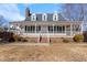 Home's exterior features a charming front porch and meticulously manicured landscaping at 20 Jenmar Dr, Fuquay Varina, NC 27526