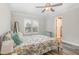 This well-lit bedroom has a window, modern ceiling fan, and neutral decor creating a serene atmosphere at 202 W Hill St, Benson, NC 27504