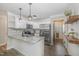 This kitchen features white cabinets, stainless steel appliances, granite countertops, and stylish pendant lighting at 202 W Hill St, Benson, NC 27504