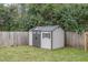Backyard featuring a shed surrounded by a wooden fence and mature trees at 202 W Hill St, Benson, NC 27504
