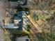 Aerial view of a charming home with a backyard deck surrounded by mature trees and approximate property lines at 215 Longbridge Dr, Cary, NC 27518