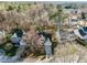 Aerial view of a home nestled among lush trees, with neighboring houses and a clear driveway visible at 215 Longbridge Dr, Cary, NC 27518