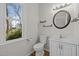 Half bathroom with white vanity, round mirror, modern fixtures, and natural light from the window at 215 Longbridge Dr, Cary, NC 27518