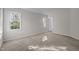 Bedroom features carpet, two bright windows, and a door to another room at 215 Longbridge Dr, Cary, NC 27518