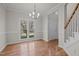 Bright dining room with hardwood floors, a modern chandelier, and large windows at 215 Longbridge Dr, Cary, NC 27518