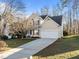 Exterior showcasing a two-story home with a spacious driveway leading to a two-car garage and manicured lawn at 215 Longbridge Dr, Cary, NC 27518
