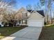 View of the two-story house featuring a two-car garage, vinyl siding, and a concrete driveway at 215 Longbridge Dr, Cary, NC 27518