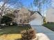 Traditional two-story home with a spacious driveway, attached garage, and mature trees in the front yard at 215 Longbridge Dr, Cary, NC 27518