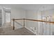View of the second story hallway featuring wood railing and a modern light fixture at 215 Longbridge Dr, Cary, NC 27518